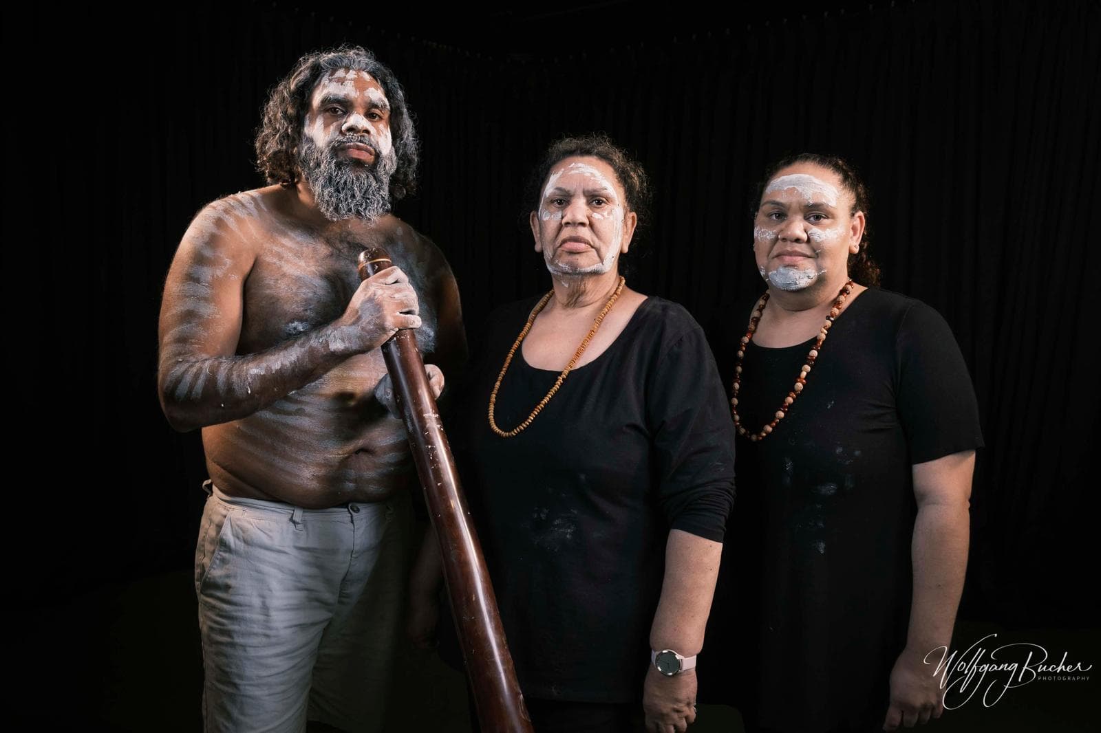 Three Giinagay community members wearing traditional body paint